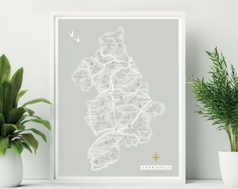 May include: A gray and white map of Snowdonia National Park in Wales, with a compass rose and the text "SNOWDONIA National Park".
