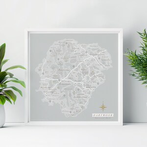 May include: A gray and white map of Dartmoor National Park in Devon, England. The map shows the location of towns and villages, including Princetown, Ashburton, and Buckfastleigh. The map is framed in a white frame.