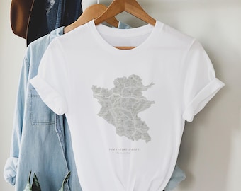 May include: White t-shirt featuring a grey outline map of the Yorkshire Dales National Park. The text "Yorkshire Dales National Park" is printed below the map.