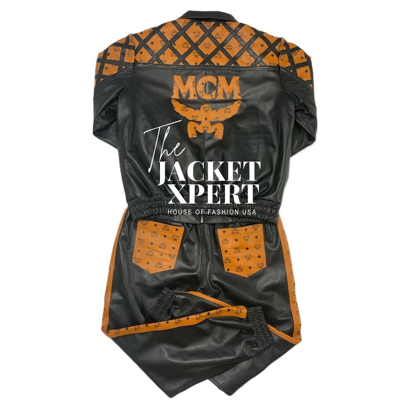 May include: Black leather jacket and matching pants set with brown accents and the MCM logo. The jacket has a collared neckline and the text "The Jacket Xpert". The pants have pockets and a drawstring waist.
