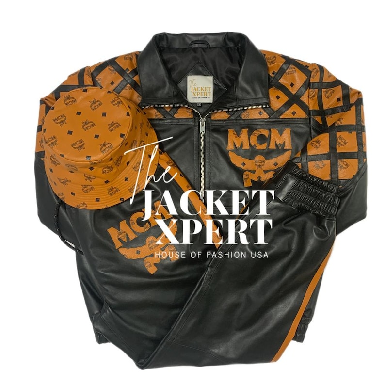 May include: Black leather jacket, pants, and bucket hat set with brown MCM logo pattern. The jacket has a zipper closure and the text "MCM" on the front. The set is from "The Jacket Xpert, House of Fashion USA."