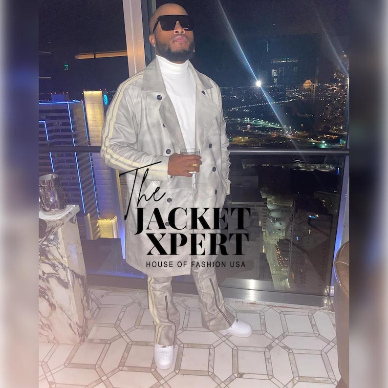 May include: A light gray trench coat with yellow stripes on the sleeves and matching pants. The outfit is paired with white sneakers. The text "The JACKET XPERT HOUSE OF FASHION USA" is visible on the image.