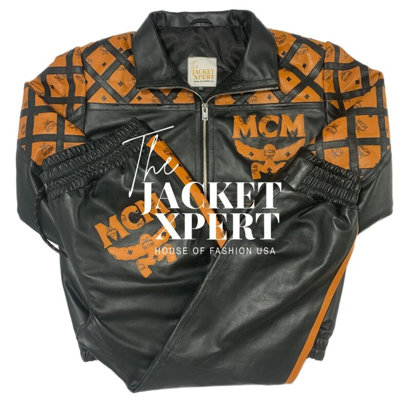 May include: Black leather jacket and matching pants set with orange MCM logo and diamond pattern accents. The jacket has a zip-up front and a collared neckline. The pants have an elastic waistband and orange stripe down the side. The text "The Jacket Xpert" is visible.
