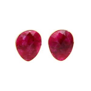 Op de afbeelding: Een paar robijnkleurige oorstekers. Elke oorbel heeft een gefacetteerde, ovaalvormige robijnsteen gezet in een goudkleurige bezel. De robijnen vertonen een diepe, rijke rode tint, tegen een witte achtergrond.