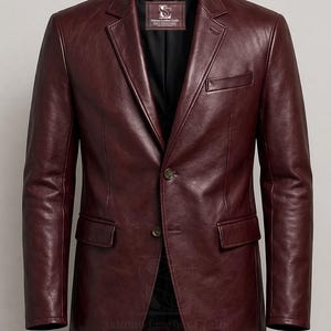 May include: A burgundy leather blazer with a two-button fastening, notched lapels, and two front pockets. The jacket has a classic design and is from Salman Leather Crafts.