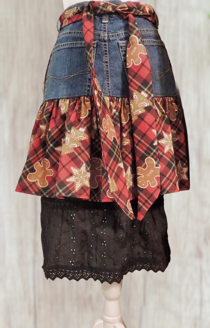 A skirt made from a denim apron and a lace overlay, featuring a plaid pattern with gingerbread man motifs.
