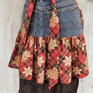 A skirt made from a denim jacket, featuring a plaid pattern and a red and black tie.