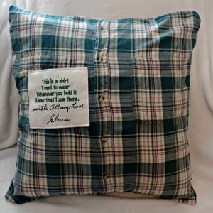 May include: A green and white plaid pillow with a white fabric patch sewn on the front. The patch has a handwritten message that reads "This is a shirt I used to wear Whenever you hold it Know that I am there. with All my Love Sleen".