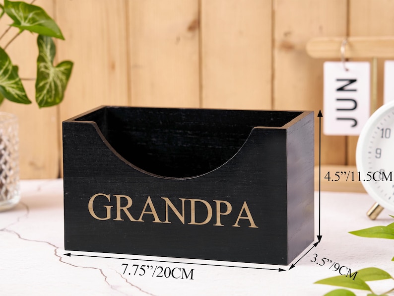 Puede incluir: Una caja de madera negra con la palabra "GRANDPA" en letras doradas. La caja mide 20 cm de largo, 9 cm de ancho y 11,5 cm de alto. La caja tiene un recorte curvo en un lado.