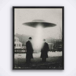 May include: Framed monochrome print showing two figures in a field, lit by a beam from a hovering UFO. The image has a grainy texture, creating a vintage aesthetic. The scene evokes a sense of mystery and retro science fiction.
