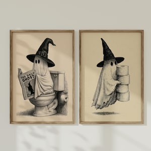Puede incluir: Dos láminas enmarcadas con ilustraciones en tinta negra y blanca de fantasmas con sombreros de bruja puntiagudos. La lámina izquierda muestra a un fantasma en el inodoro leyendo un periódico titulado The Daily Ghost. La derecha muestra un fantasma.