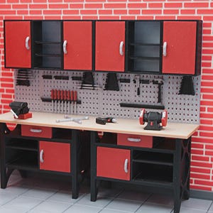Puede incluir: Miniatura de taller con armarios rojos y negros, un panel perforado y un banco de trabajo. El banco de trabajo tiene cajones y una variedad de herramientas, incluyendo una amoladora y un taladro. El fondo es una pared de ladrillo rojo.