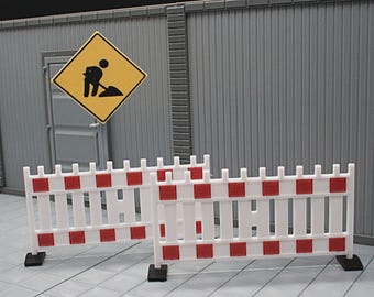 May include: Miniature construction scene featuring white and red barricades, a yellow warning sign with a worker icon, and a gray building. The scene is set on a gray tiled surface.