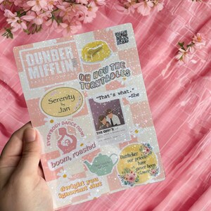 May include: A sticker sheet featuring quotes and images from the TV show "The Office." Phrases include "Oh How The Turntables" and "That's what." The design incorporates a pink and white checkered pattern, with various character references.