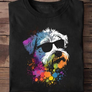 Peut inclure: T-shirt noir avec une illustration colorée d'un chien portant des lunettes de soleil. Le pelage du chien est blanc, avec des éclaboussures de peinture colorées en bleu, violet, orange et vert. Le motif est centré sur le t-shirt.