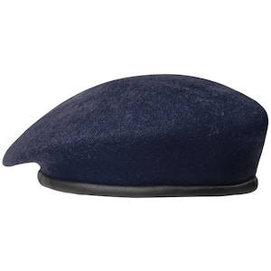 May include: A dark navy blue beret featuring a soft, felted wool-like texture on the crown and a smooth, black leather-like trim along the bottom edge. The hat has a rounded, classic shape and is presented against a plain white background.