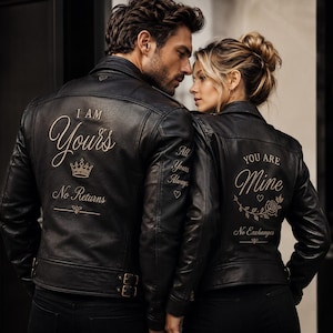May include: Black leather jackets with gold lettering. One jacket reads "I AM Yours" with a crown and "No Returns." The other jacket says "YOU ARE Mine" with a floral design and "No Exchanges." Both jackets have "All Yours Always" on the sleeves.
