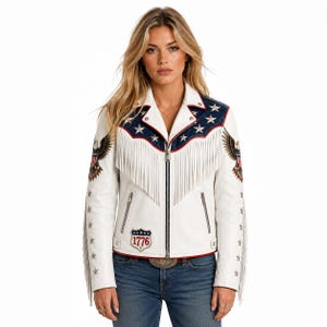 May include: A white leather motorcycle jacket featuring a blue yoke with silver star appliqu&eacute;s, long white fringe across the chest and sleeves, eagle patches on the shoulders, and a shield patch on the lower front with the text 1776 in red.