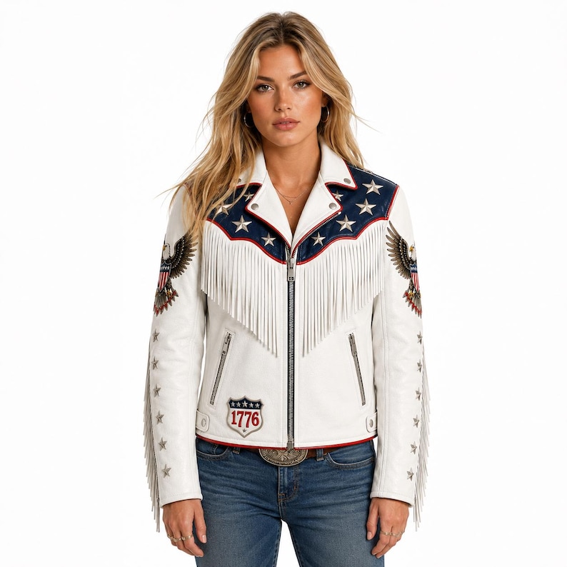 May include: A white leather motorcycle jacket featuring a blue yoke with silver star appliqu&eacute;s, long white fringe across the chest and sleeves, eagle patches on the shoulders, and a shield patch on the lower front with the text 1776 in red.