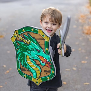 May include: A white ceramic mug with a black handle and the text "But First, Coffee" in a black, handwritten-style font. The mug is on a white surface.