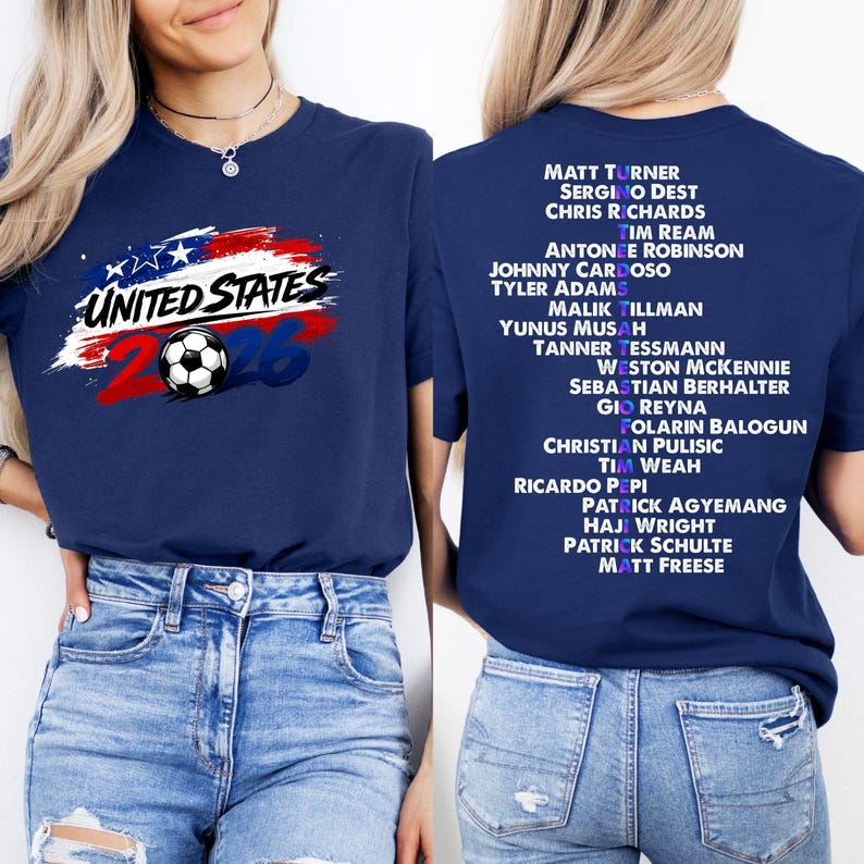 May include: A navy blue t-shirt with the text "UNITED STATES 26" and a soccer ball graphic. The back of the shirt displays a list of soccer player names. The design uses red, white, and blue colours.