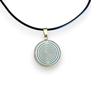 May include: A gold-toned pendant necklace featuring a circular pendant with a spiral design. The pendant hangs from a black cord. The spiral design is silver and light blue, creating a striking contrast.
