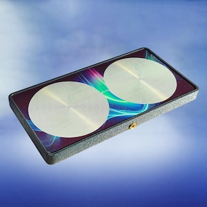 May include: A rectangular black device with a textured frame featuring two circular silver metallic discs on its surface. The background panel displays a vibrant abstract pattern of swirling blue, green, and purple light waves with a small gold screw.