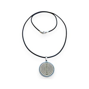 Könnte beinhalten: Halskette mit silberfarbenem Anhänger und schwarzem Band. Der runde Anhänger zeigt ein konzentrisches Spiralmuster in Weiß und Silber. Die Halskette hat einen silbernen Verschluss.