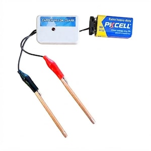 Pode incluir: Um dispositivo Zapper Hulda Clark com uma caixa de controlo retangular branca com uma luz indicadora vermelha, ligada a uma bateria de 9V PKCELL. Duas hastes de cobre estão fixadas através de pinças jacaré com capas de plástico vermelhas e pretas.