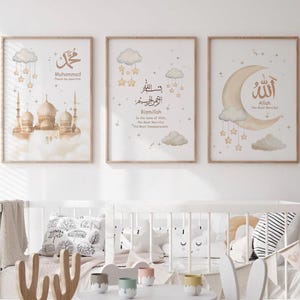 May include: Three framed art prints with Islamic themes. The prints feature illustrations of a mosque, clouds, stars, and a crescent moon. The color palette includes beige, gold, and white. The prints are displayed above a white crib.