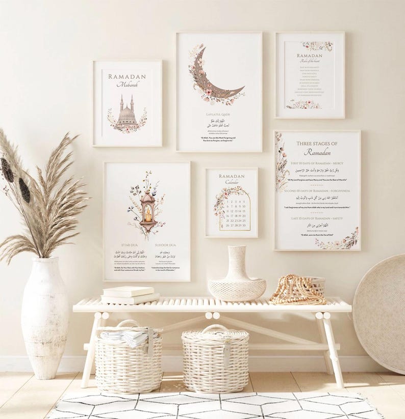 May include: A collection of framed art prints with floral and calligraphy designs, including a crescent moon, a lantern, and a calendar. The prints are in neutral tones and feature the word "Ramadan". The art is displayed above a white bench with woven baskets.