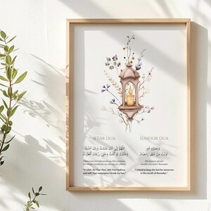 May include: Framed art print featuring Islamic prayers in Arabic and English. The artwork includes a watercolor illustration of a lantern with a lit candle, surrounded by floral accents. The text includes "IFTAR DUA" and "SUHOOR DUA".