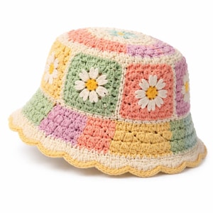 Può includere: Un cappello a secchiello all'uncinetto colorato con un design patchwork e motivi a margherita. L'orlo del cappello è smerlato e la tavolozza dei colori comprende tonalità pastello di giallo, rosa, verde e viola. Un accessorio alla moda.