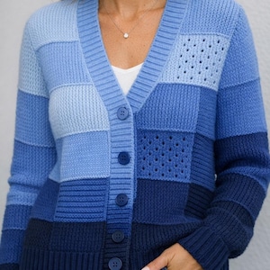 Könnte beinhalten: Blauer Cardigan mit Patchwork-Design in verschiedenen Blautönen. Der V-Ausschnitt-Pullover hat eine Knopfleiste vorne und ein strukturiertes Strickmuster. Der Cardigan hat eine Mischung aus einfarbigen und perforierten Strickbahnen.