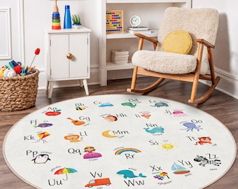 Puede incluir: Una alfombra redonda y blanquecina para niños, con el alfabeto y coloridas ilustraciones. Cada letra tiene una imagen correspondiente, como una manzana para 'A' y una cebra para 'Z'. Ideal para una sala de juegos o guardería.