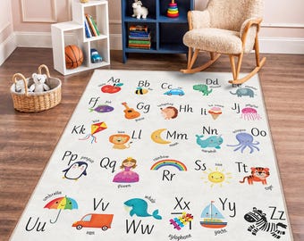 Puede incluir: Una alfombra rectangular infantil de color blanquecino con el alfabeto e ilustraciones coloridas. Cada letra tiene una imagen correspondiente, como una manzana para 'A', una abeja para 'B' y una cebra para 'Z'. La alfombra está diseñada para el juego educativo.