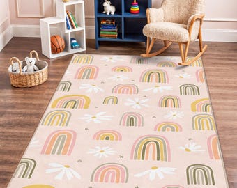 May include: A rectangular area rug with a repeating pattern of rainbows and daisies on a light pink background. The rainbows feature pastel colors, and the daisies are white. The rug is designed for a child's room.