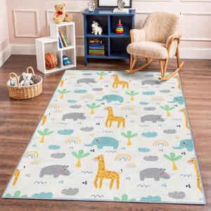 Könnte beinhalten: Rechteckiger Teppich mit Safari-Motiv. Der Teppich zeigt ein sich wiederholendes Muster aus Giraffen, Elefanten, Flusspferden, Palmen, Wolken und Regenbogen in Gelb-, Blau-, Grün- und Grautönen auf weißem Hintergrund. Metrische Maße.