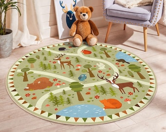 Puede incluir: Una alfombra redonda para niños de color verde claro con un diseño de escena de bosque. La alfombra presenta ilustraciones de ciervos, osos, zorros, árboles y un estanque azul. Caminos blancos serpentean por el bosque, y el borde tiene un patrón triangular.