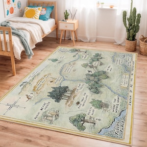 May include: A rectangular area rug featuring a map illustration with text and drawings. The map depicts a whimsical landscape with trees, houses, and a river. The rug has a cream-colored background with a yellow border. The text includes "Pooh Bears House" and "Floody Place."
