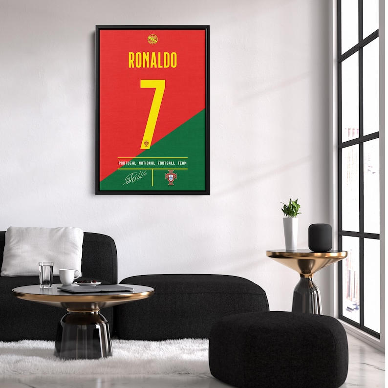 K&ouml;nnte beinhalten: Gerahmtes Poster mit dem Namen "RONALDO" in gelber Schrift &uuml;ber der Zahl "7" auf rotem und gr&uuml;nem Hintergrund. Die Worte "PORTUGAL NATIONAL FOOTBALL TEAM" stehen unter der Zahl. Enth&auml;lt eine Unterschrift und das Logo des portugiesischen Fu&szlig;ballverbands.