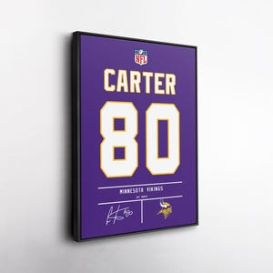 May include: Framed artwork featuring a purple jersey design with the name "CARTER" and the number "80" in white and gold. The NFL logo is at the top, with the Minnesota Vikings logo at the bottom. Includes a signature.