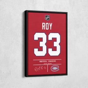 May include: Framed canvas art featuring a red Montreal Canadiens jersey design. The jersey displays the name "ROY" and the number "33" in white. Includes the NHL logo, team name, and a signature. The canvas is framed in black.