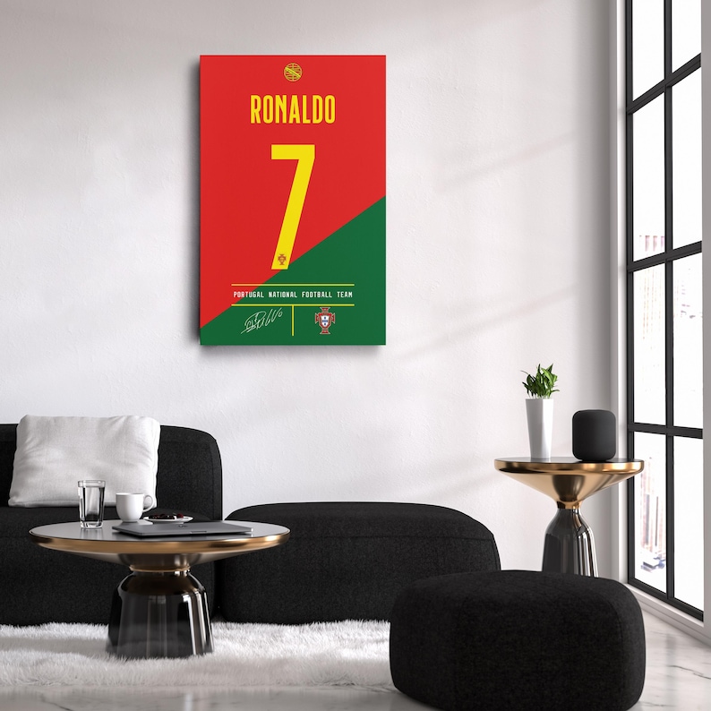 K&ouml;nnte beinhalten: Gerahmter Wandkunstdruck mit dem Namen "RONALDO" in gelber Schrift &uuml;ber der Zahl "7". Der Hintergrund ist diagonal geteilt, oben rot und unten gr&uuml;n. Der Text "PORTUGAL NATIONAL FOOTBALL TEAM" ist ebenfalls sichtbar.