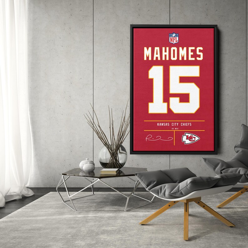 May include: Framed red Kansas City Chiefs jersey art featuring the name "Mahomes" and the number "15" in white. The artwork includes the NFL logo and the team's logo. The framed art is displayed in a modern living room setting.