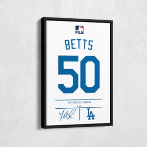 May include: Framed print of a Los Angeles Dodgers jersey. The jersey features the name "BETTS" above the number "50" in blue. The MLB logo is at the top. The bottom includes the team name, a signature, and the Dodgers logo.