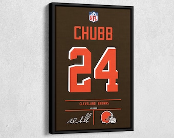 May include: Framed artwork featuring the name "CHUBB" and the number "24" in orange on a brown background, with the NFL logo at the top. The words "Cleveland Browns" and a signature are at the bottom, along with a helmet graphic.