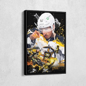 May include: Framed art print featuring a hockey player in a white helmet with the number 63, pointing forward. The artwork has a black background with yellow and white accents, and the Boston Bruins logo.