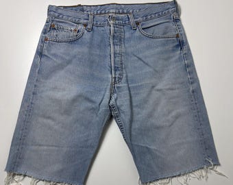 Puede incluir: Pantalones cortos vaqueros de color azul claro con bragueta de botones y dobladillo deshilachado. Los pantalones cortos tienen un estilo clásico de cinco bolsillos y un lavado descolorido. Un estilo casual.
