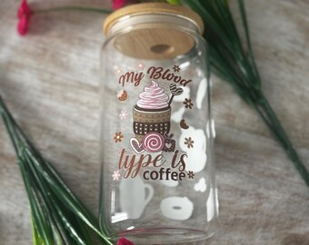 May include: A clear glass beverage can with a wooden lid. The glass features a graphic of a coffee drink with the text "my blood type is coffee". White coffee-themed shapes are scattered around the glass.